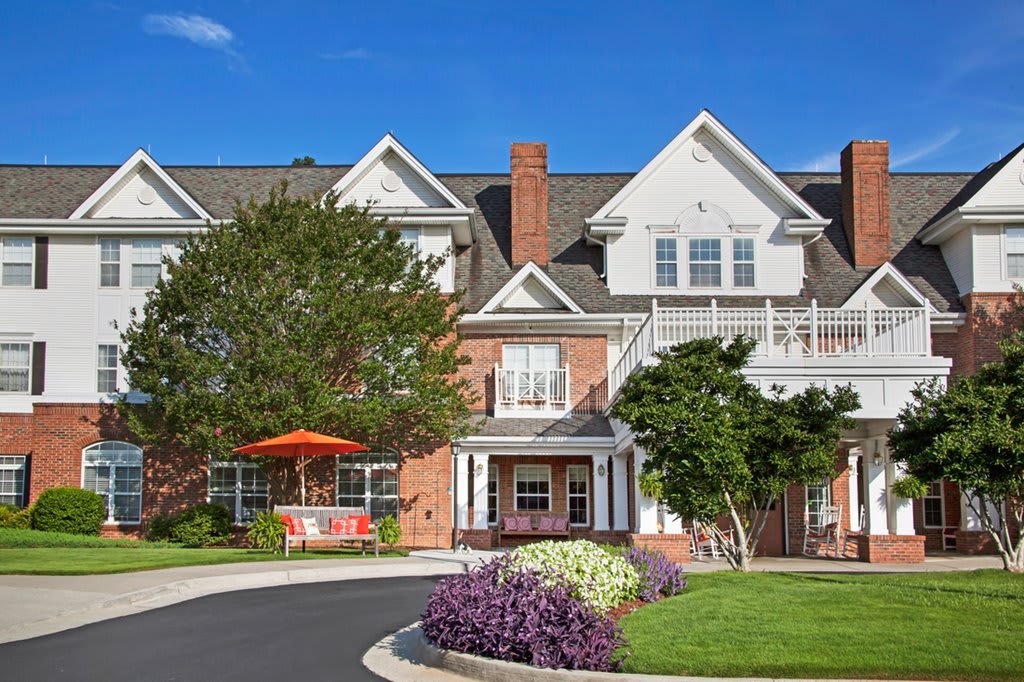 A picturesque residential building with a well-maintained garden and driveway.