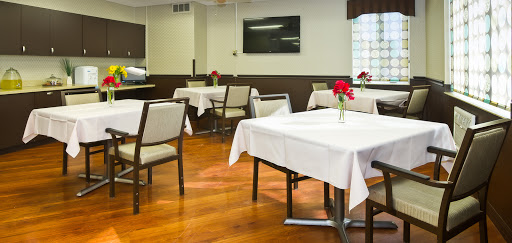 A cozy restaurant dining area with neatly set tables and floral centerpieces.