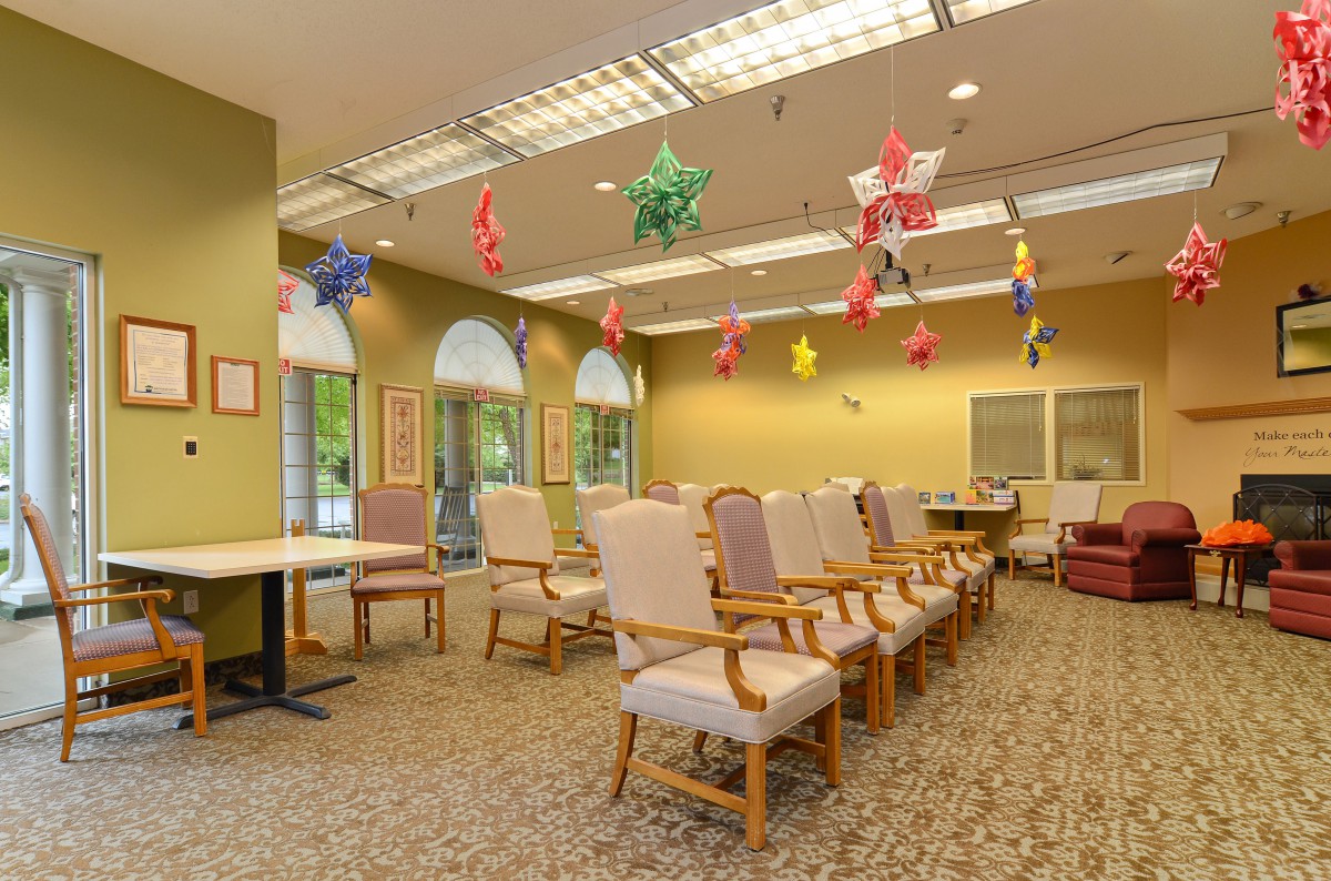 A spacious waiting area with rows of chairs, colorful ceiling decorations, and ample lighting.