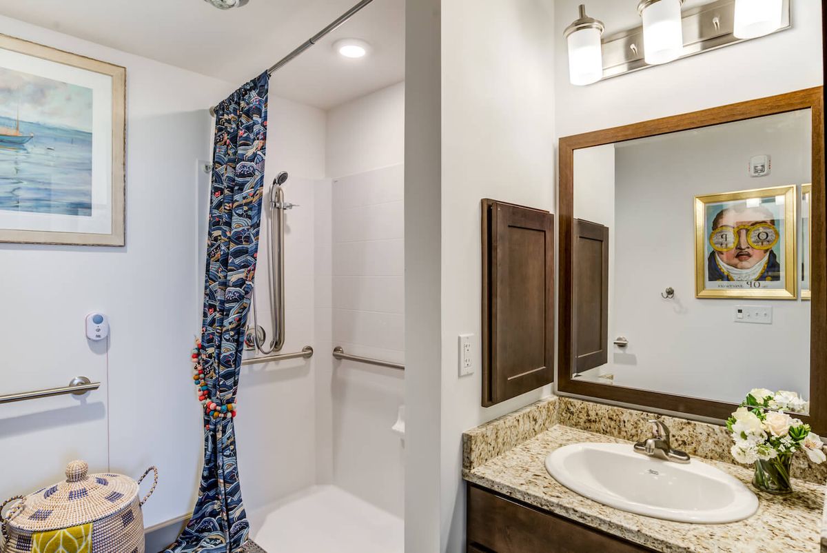 A modern bathroom with a shower, sink, and mirror.