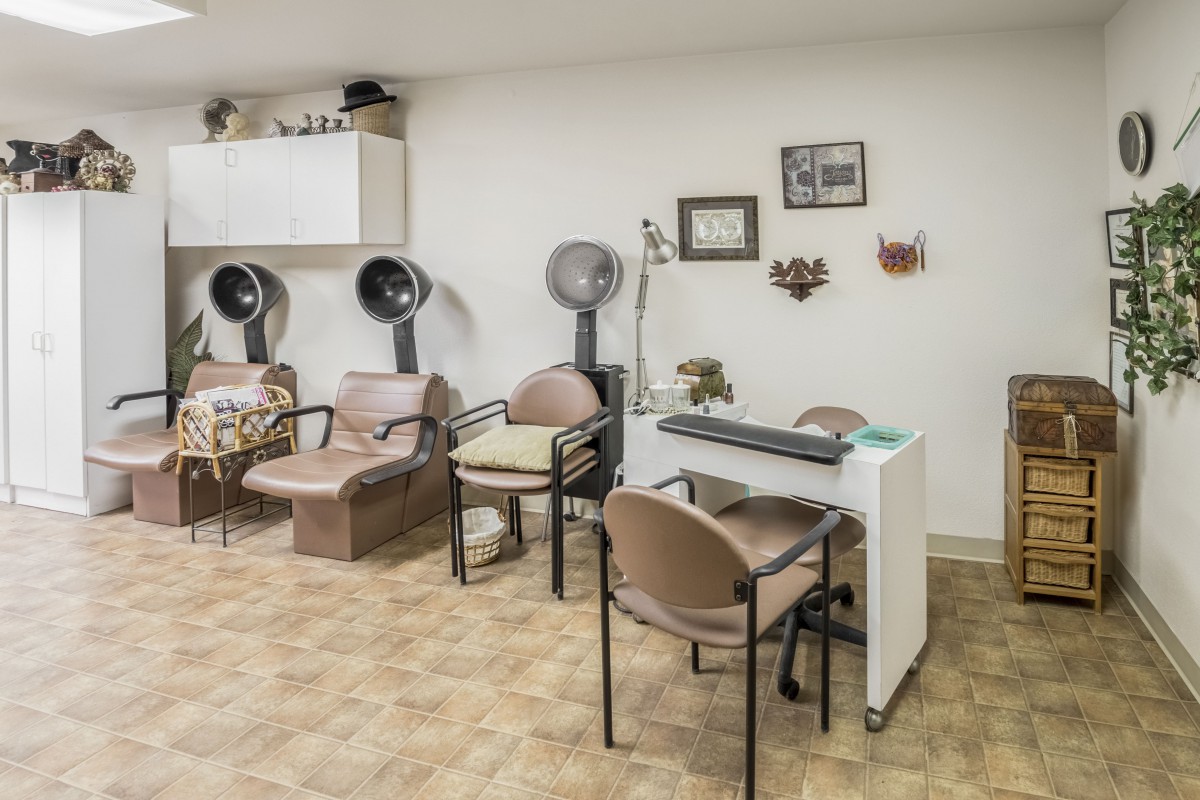 A vintage-style salon interior with hair drying stations and a manicure desk.