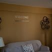 A cozy living room featuring a sofa, decorative wall art, and a lamp.
