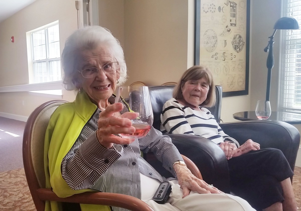 Two elderly women enjoying a relaxing moment together in a cozy living room.