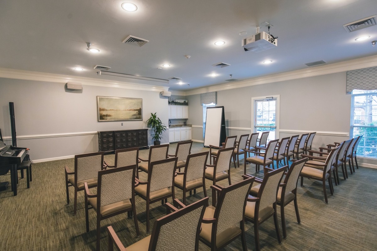 An organized conference room with rows of chairs facing a presentation area.