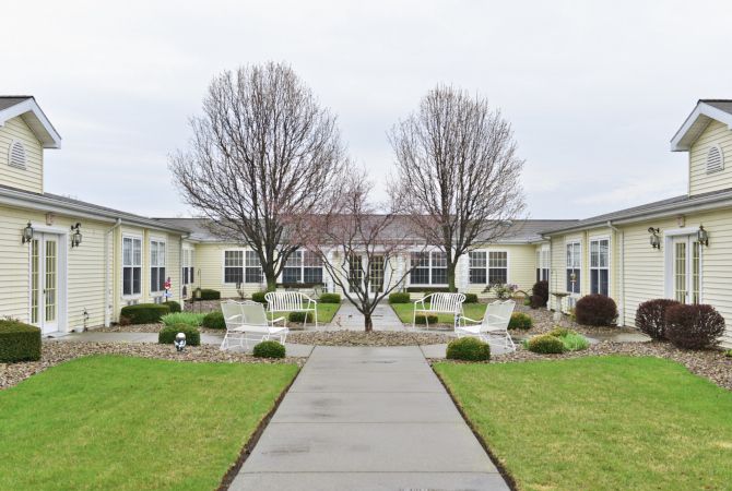 A neatly landscaped courtyard with benches and an overcast sky.