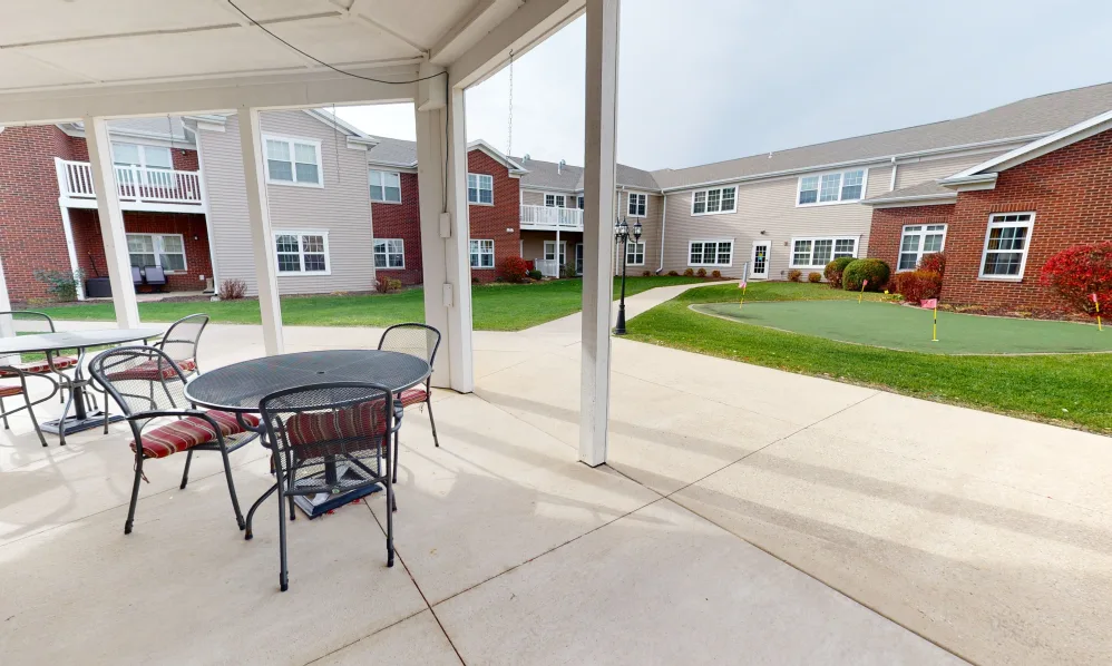 A patio area with seating overlooking a courtyard in an apartment complex.