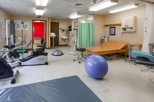An overview of a physical therapy room equipped for rehabilitation and exercise.