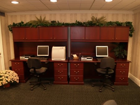 A neatly organized office workspace with two desks and computers.