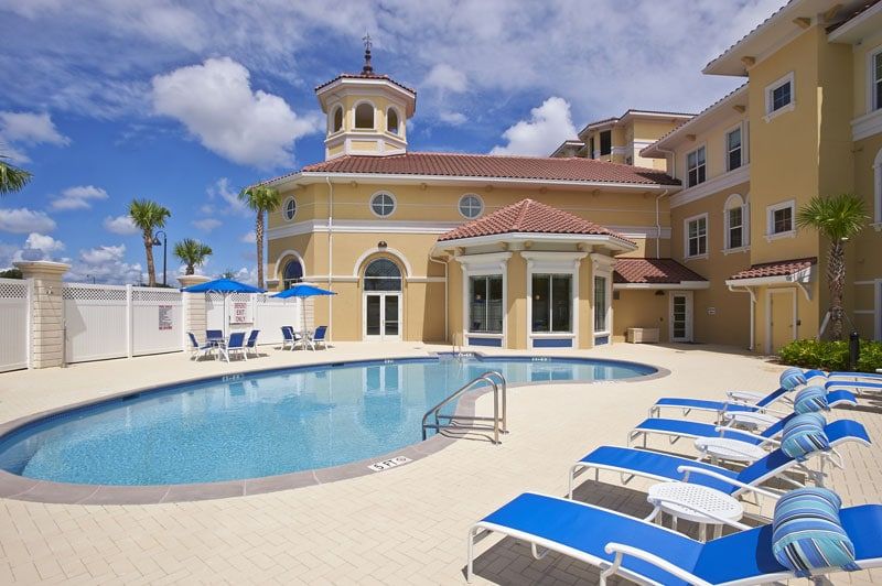 A luxurious hotel with an inviting outdoor swimming pool and sun loungers under a sunny sky.