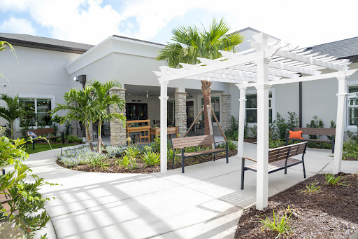 A modern outdoor seating area surrounded by lush greenery and architectural elements.