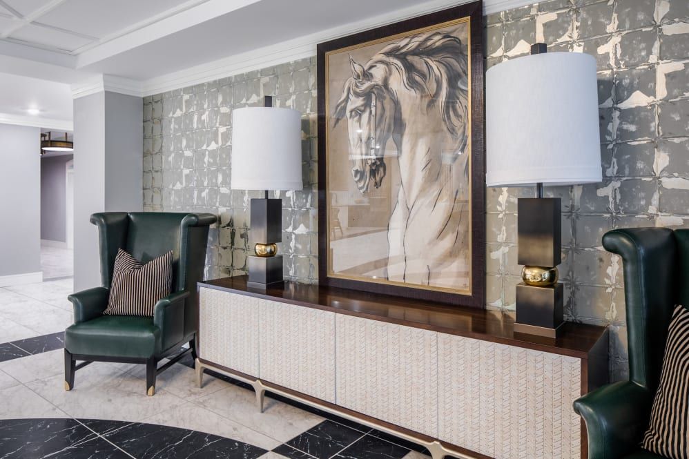 A stylish interior featuring a large horse portrait, flanked by modern lamps on a sleek sideboard.