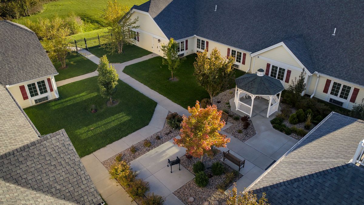 Aerial view of a landscaped courtyard with pathways, a gazebo, and autumn-colored trees.