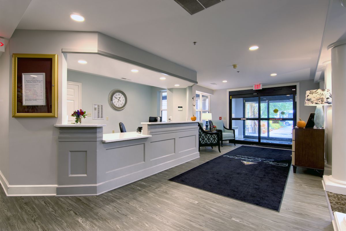 A modern reception area with a desk, seating, and decor.
