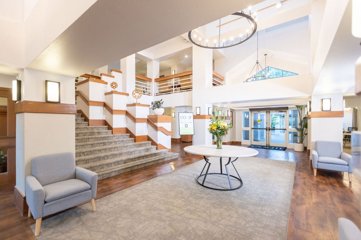 A spacious and elegantly designed lobby with a modern staircase and chandelier.