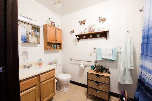 A cozy bathroom featuring wooden cabinets, decorative butterflies, and organized storage.