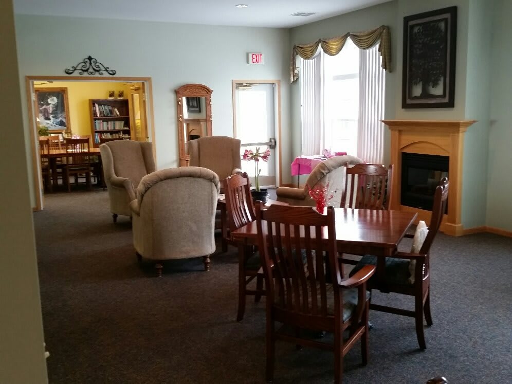 A cozy living room with comfortable seating, a fireplace, and large windows.