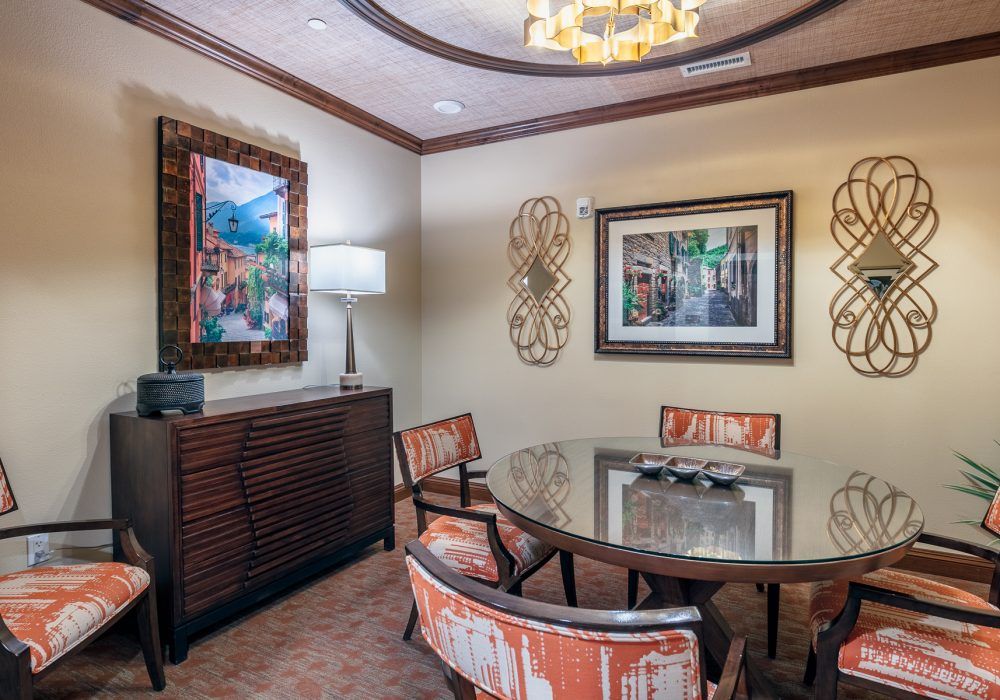 A professionally decorated meeting room featuring a round table, stylish chairs, and contemporary artwork.