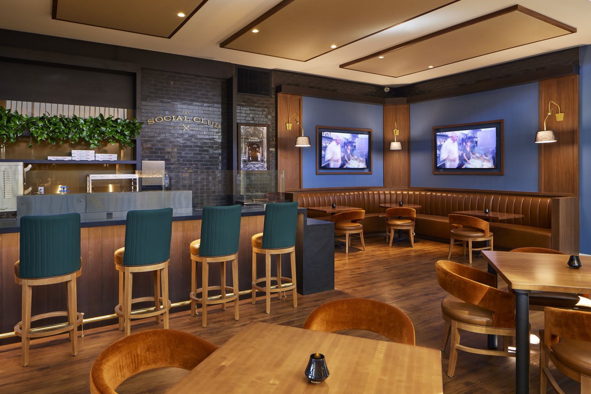 A modern bar and restaurant interior with wooden furniture and televisions.