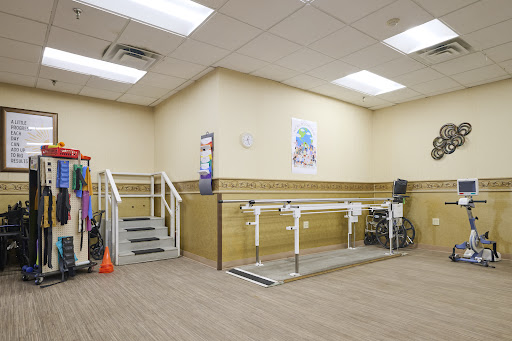 A physical therapy room equipped with parallel bars and stairs for rehabilitation exercises.