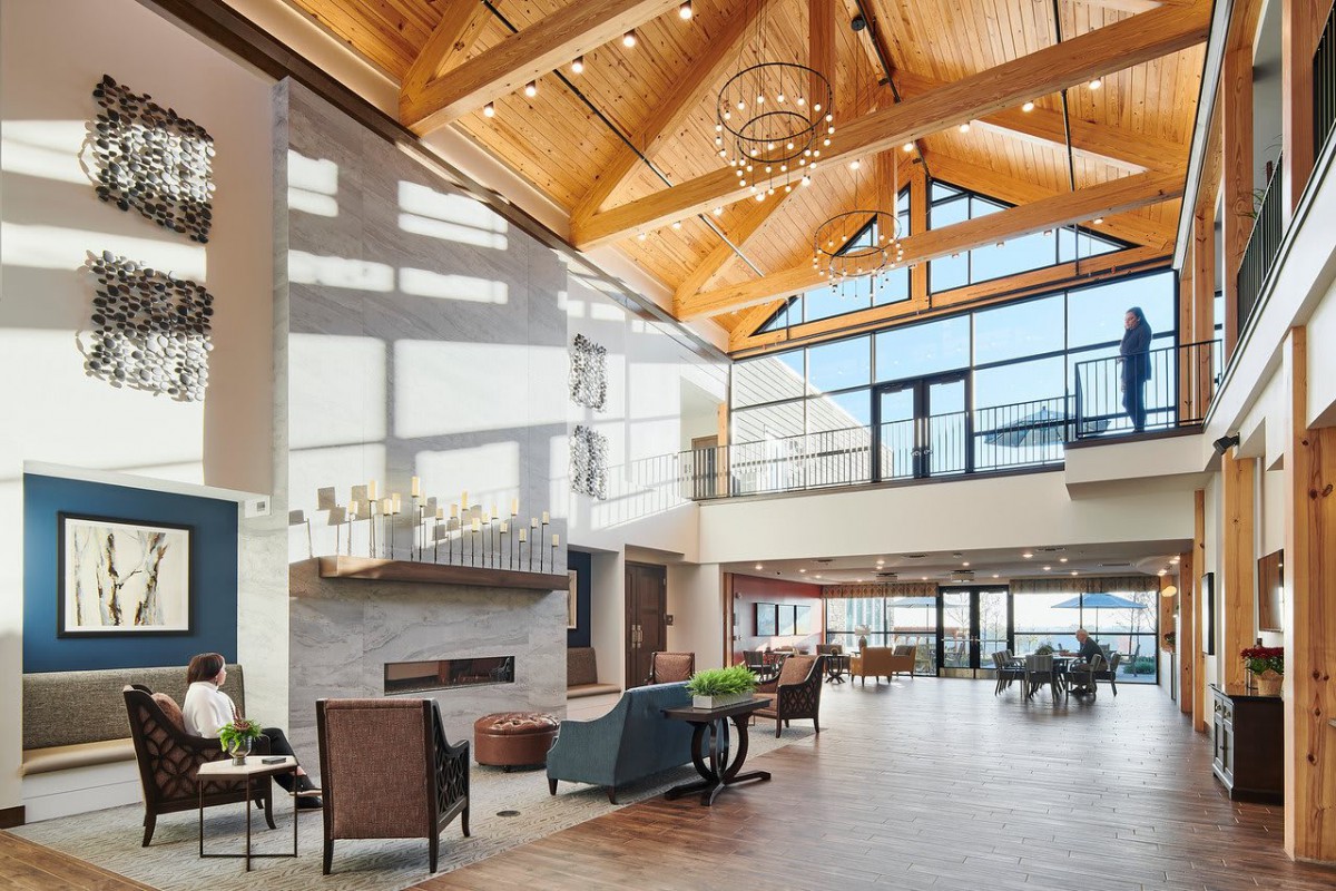 A spacious modern lobby with a wooden ceiling and large windows letting in natural light.