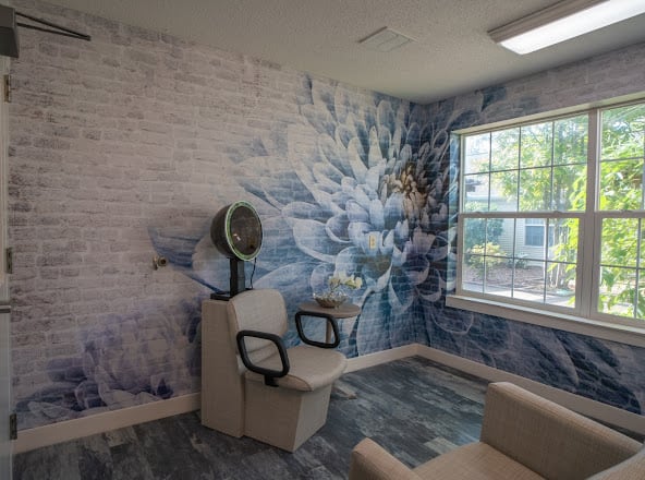 A modern salon interior featuring a decorative wall mural and hairdressing station.
