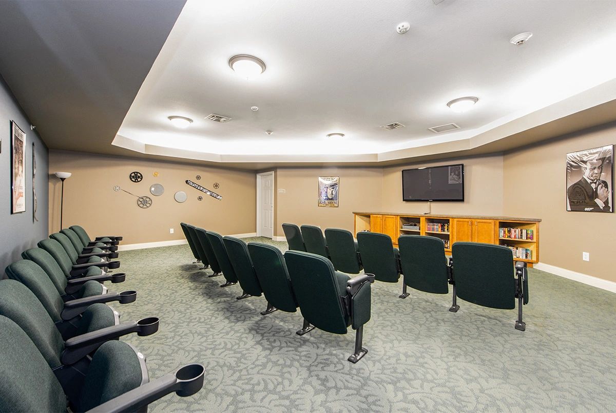 A small theater room with rows of seating facing a large screen.