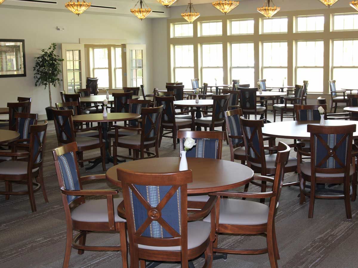 An empty dining room with neatly arranged tables and chairs.