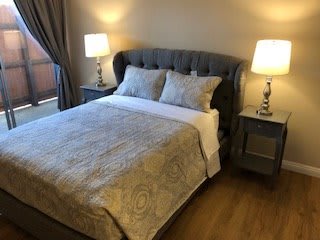 A cozy bedroom with a neatly made bed and ambient lighting.