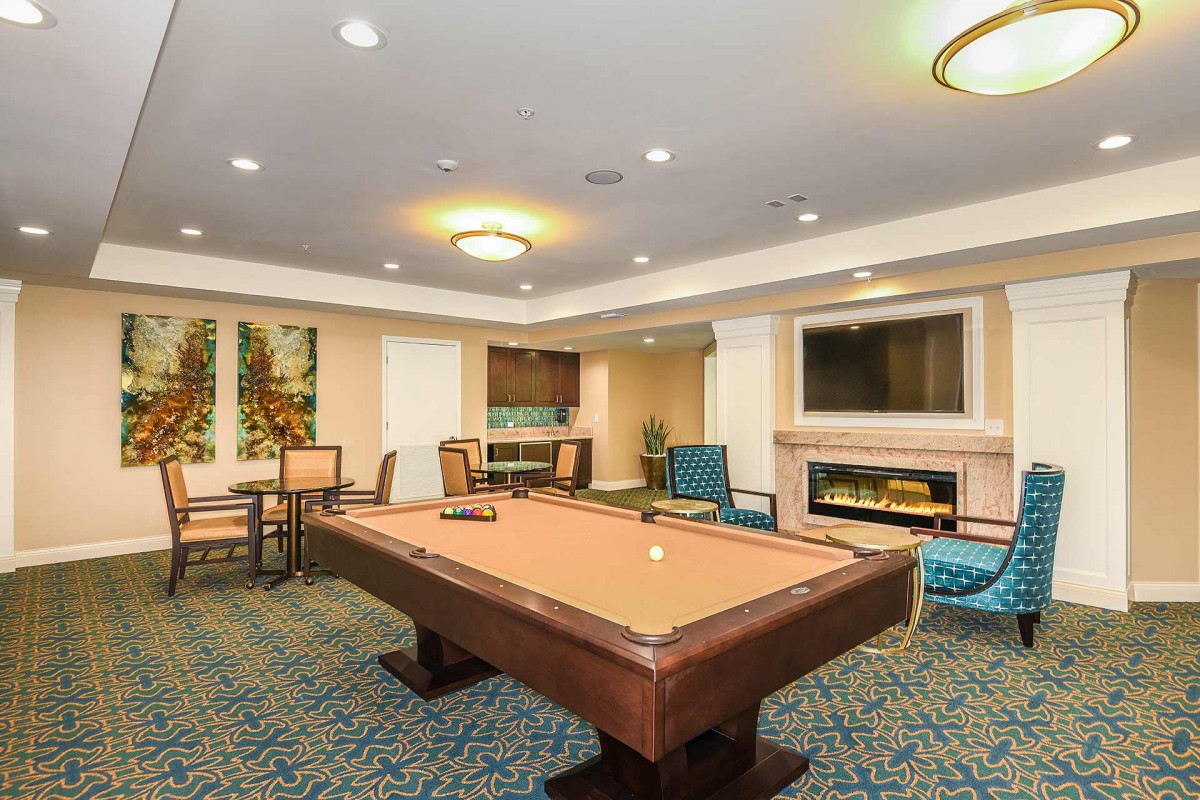 A cozy game room with a pool table and comfortable seating.