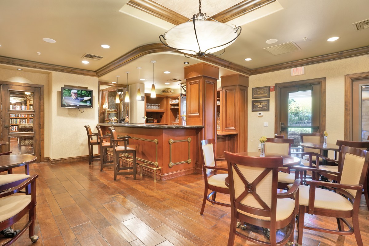 A luxurious kitchen and bar area with wooden floors and elegant seating.