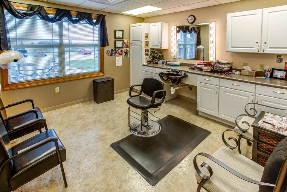 An interior view of a hair salon featuring a barber chair and styling station.