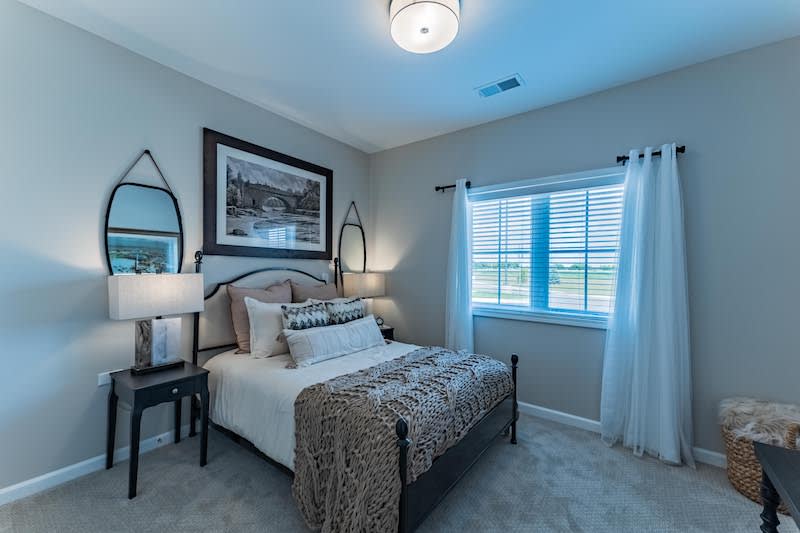 A cozy modern bedroom with elegant decor and ample natural light.
