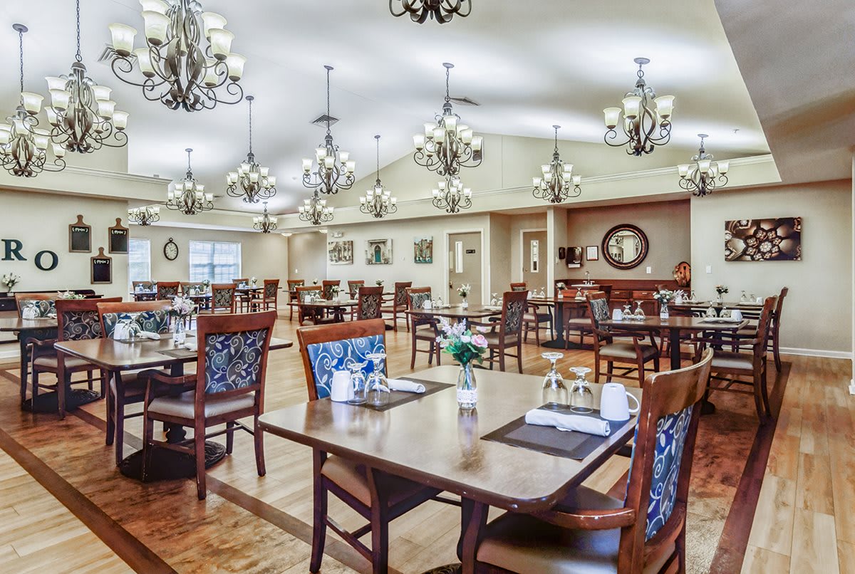 Spacious dining room with elegant chandeliers and well-set tables.