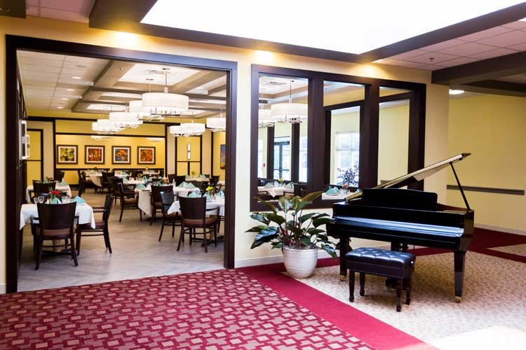 An elegant restaurant interior featuring a grand piano and a well-arranged dining area.