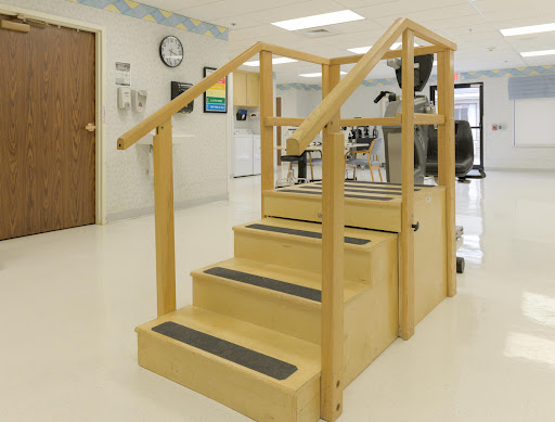 A wooden staircase with handrails designed for rehabilitation and physical therapy.