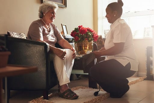 A caregiver assisting an elderly person during a home visit.