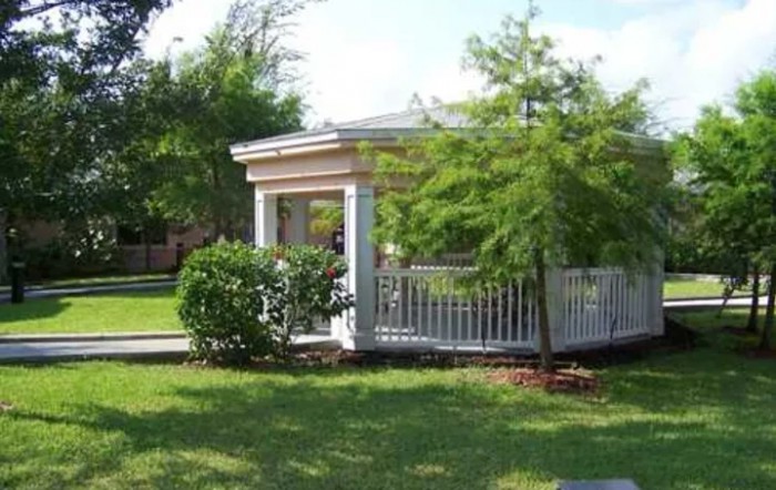 A gazebo surrounded by lush greenery in a garden setting.