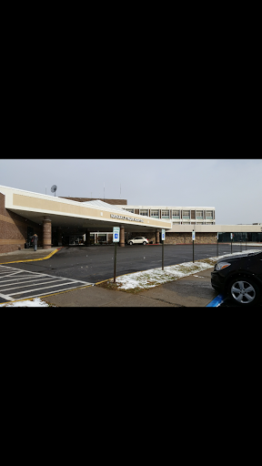 A view of a commercial building with a parking lot, showing some remnants of snow.