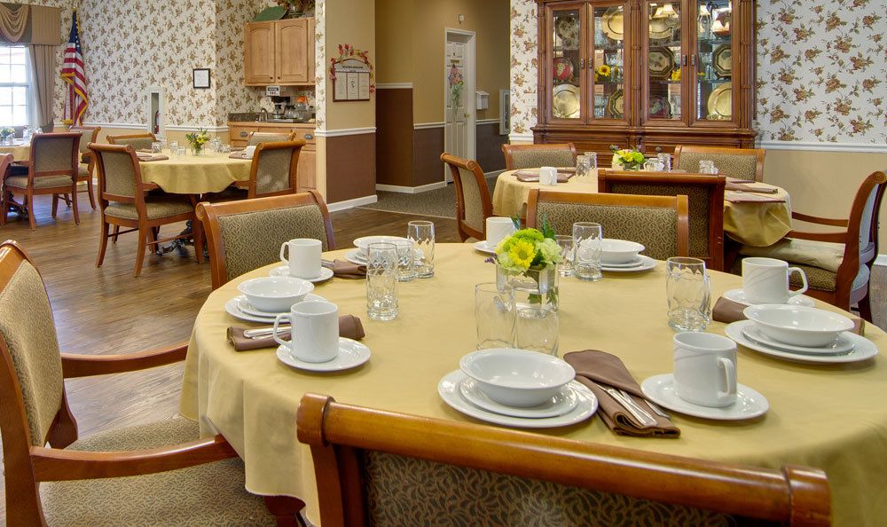 A well-set dining area with neatly arranged tables and chairs, featuring elegant tableware and decor.