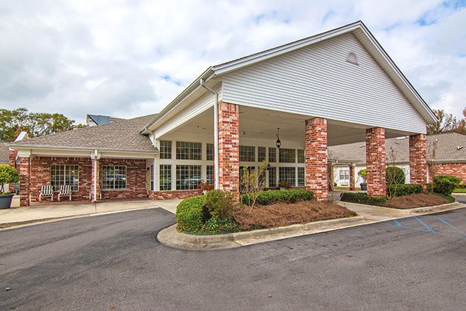 A building with a covered entrance and landscaped driveway.