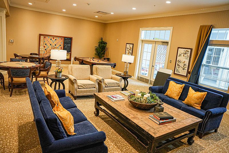 A cozy living room with blue sofas, a wooden coffee table, and tasteful artwork on beige walls.