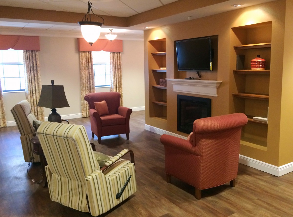 A comfortable living room with armchairs, a fireplace, and a television.