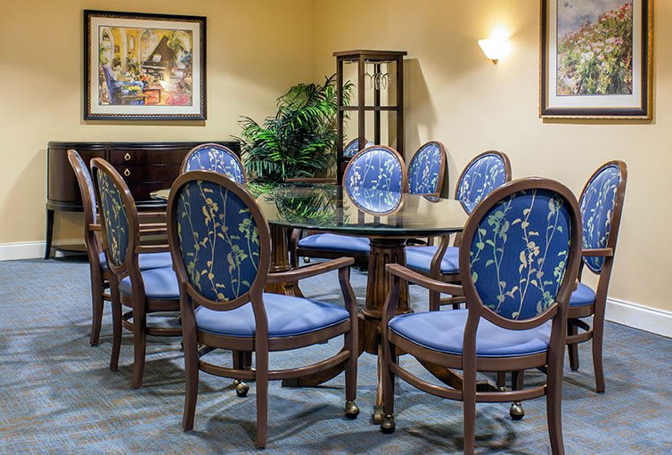 A beautifully decorated dining area featuring a round table surrounded by floral-patterned chairs.