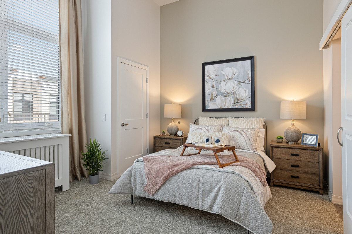 A cozy, elegantly decorated bedroom with a neatly made bed and soft lighting.