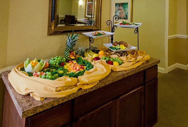 A decorative buffet display featuring an assortment of colorful fruits, beautifully arranged on a countertop.