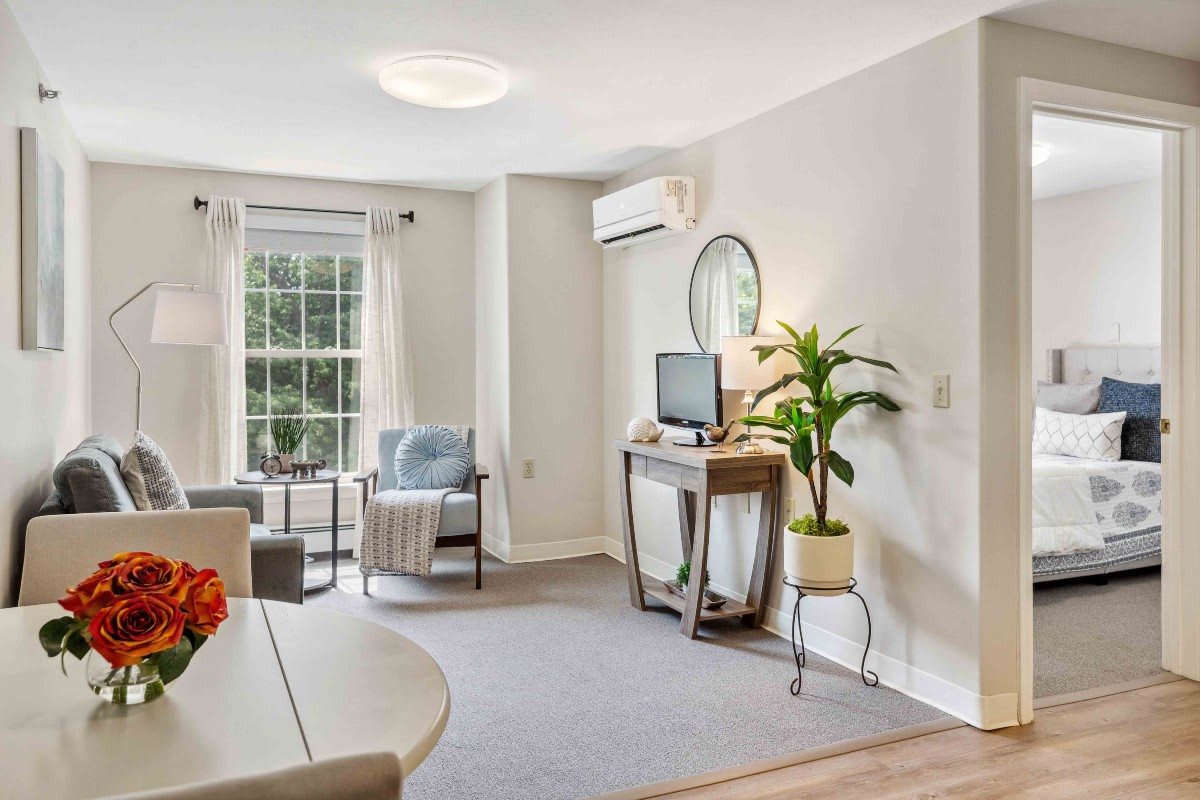 A cozy living room with a TV, comfortable seating, and plenty of natural light.