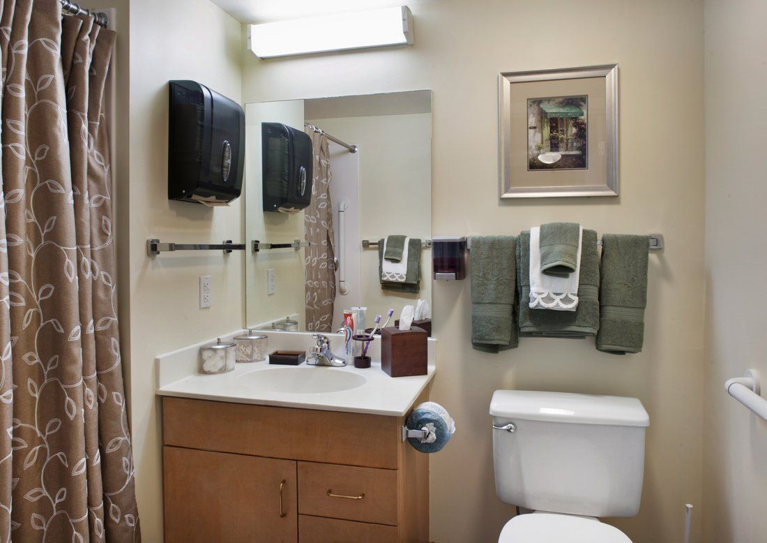 A tidy bathroom with a sink, mirror, and neatly arranged towels.