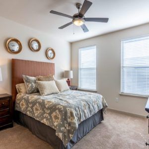 A cozy bedroom with a stylish bed, pillows, and wall decor.