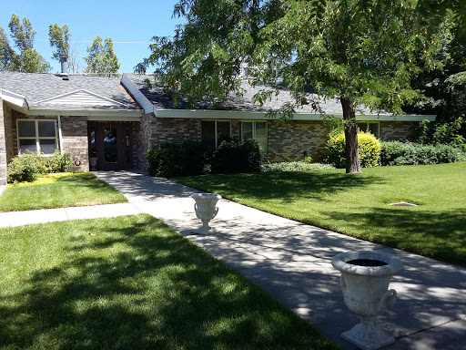 A beautiful residential home surrounded by lush greenery and a well-maintained pathway.