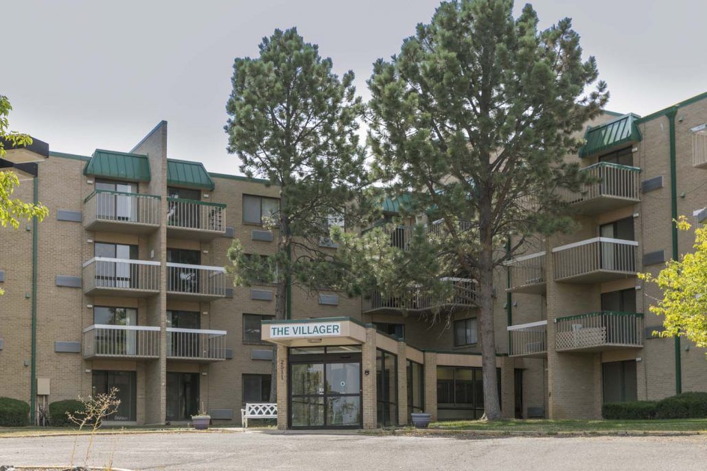 An apartment building with trees and an entrance area.